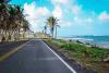 Image of a beautiful beach road with a cloudy blue sky in the background