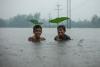 Two smiling boys are under flood in Chittagong, Bangladesh