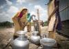 A group of women is using manual pump to bring underground water for use