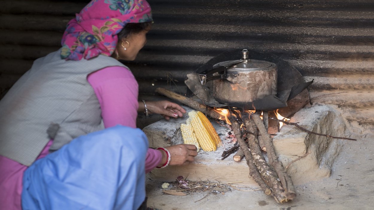         Woman cooking with an old stove
      