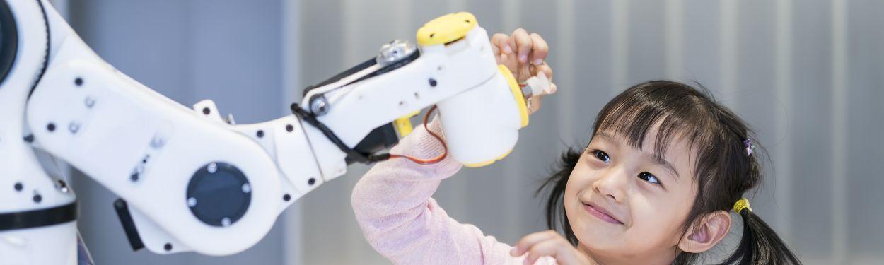 Little girl playing with a robot